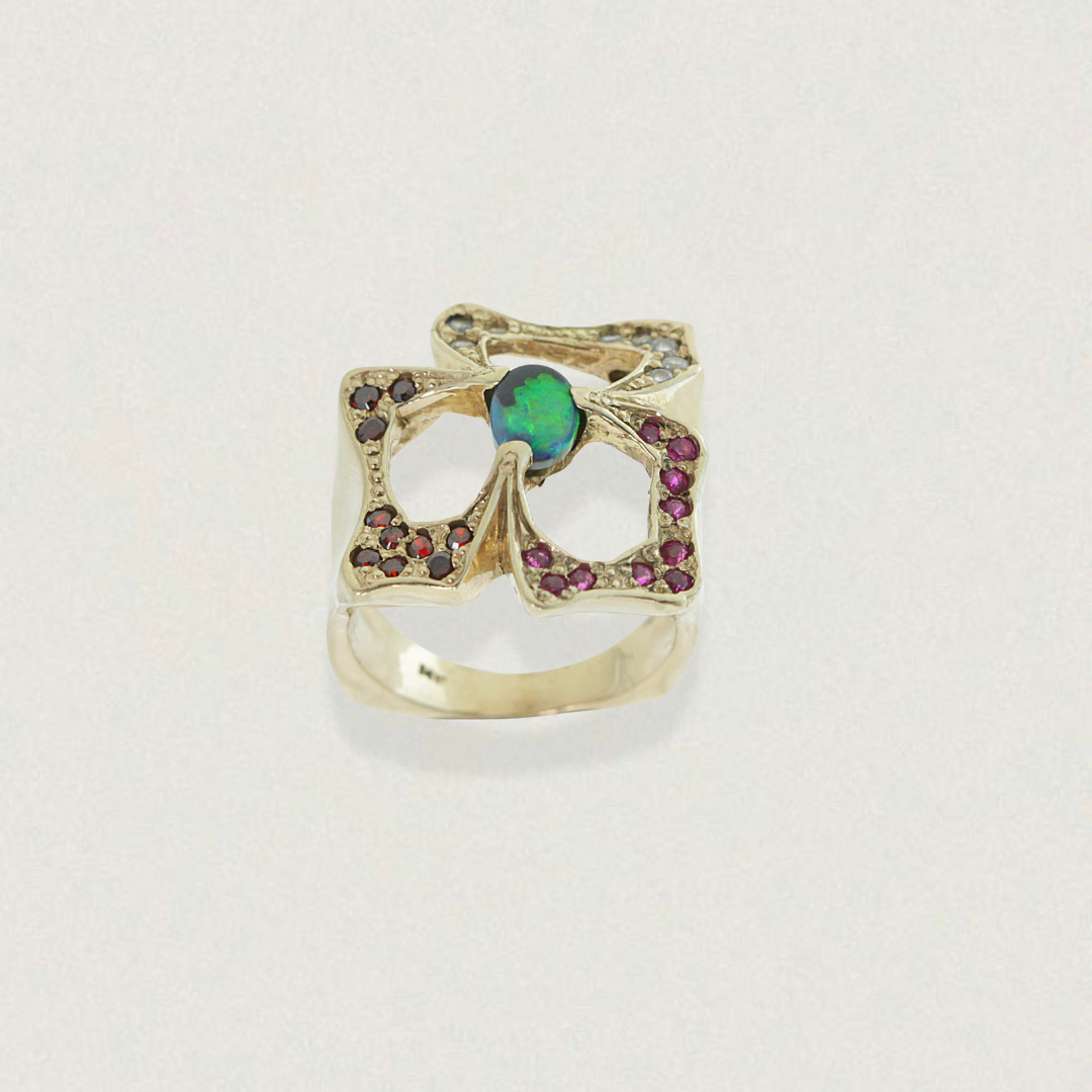 0.50ct Lightning Ridge black opal statement ring in 14ct yellow gold with garnet and purple sapphires, front view.