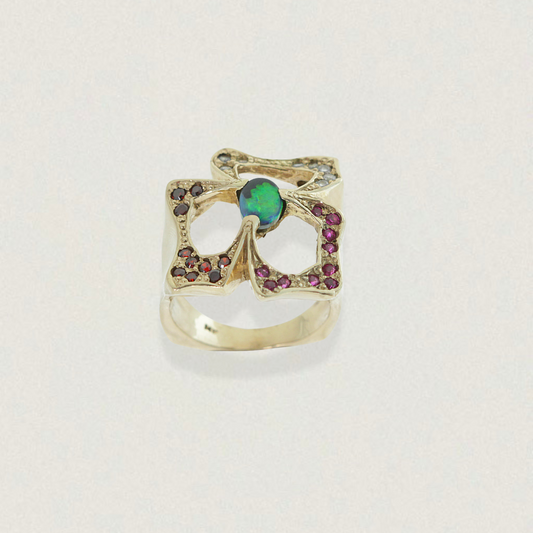 0.50ct Lightning Ridge black opal statement ring in 14ct yellow gold with garnet and purple sapphires, front view.