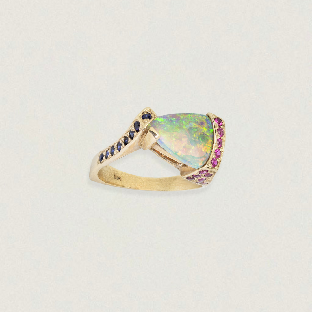 Triangular Lightning Ridge opal ring with sapphire accents in 14ct yellow gold, three-quarter view on white.