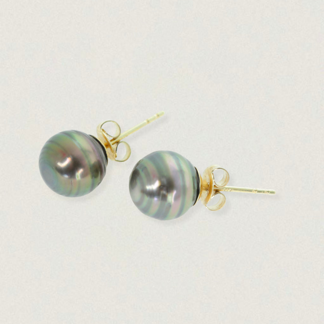 Pair of 10mm black Tahitian pearl stud earrings set in 14ct yellow gold, up-cycled materials, product on light background.