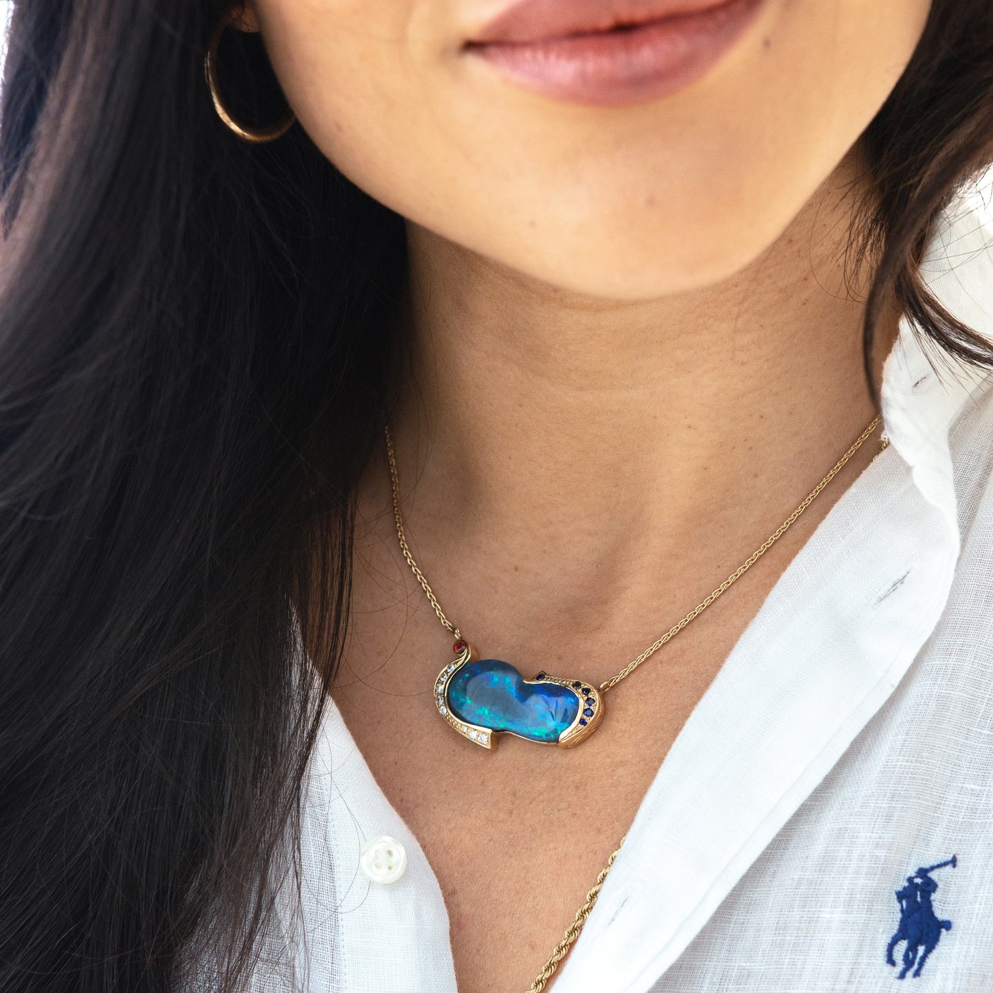 Model wearing 13.40ct Lightning Ridge opal, sapphire and diamond necklace in 14ct yellow gold at the collarbone.