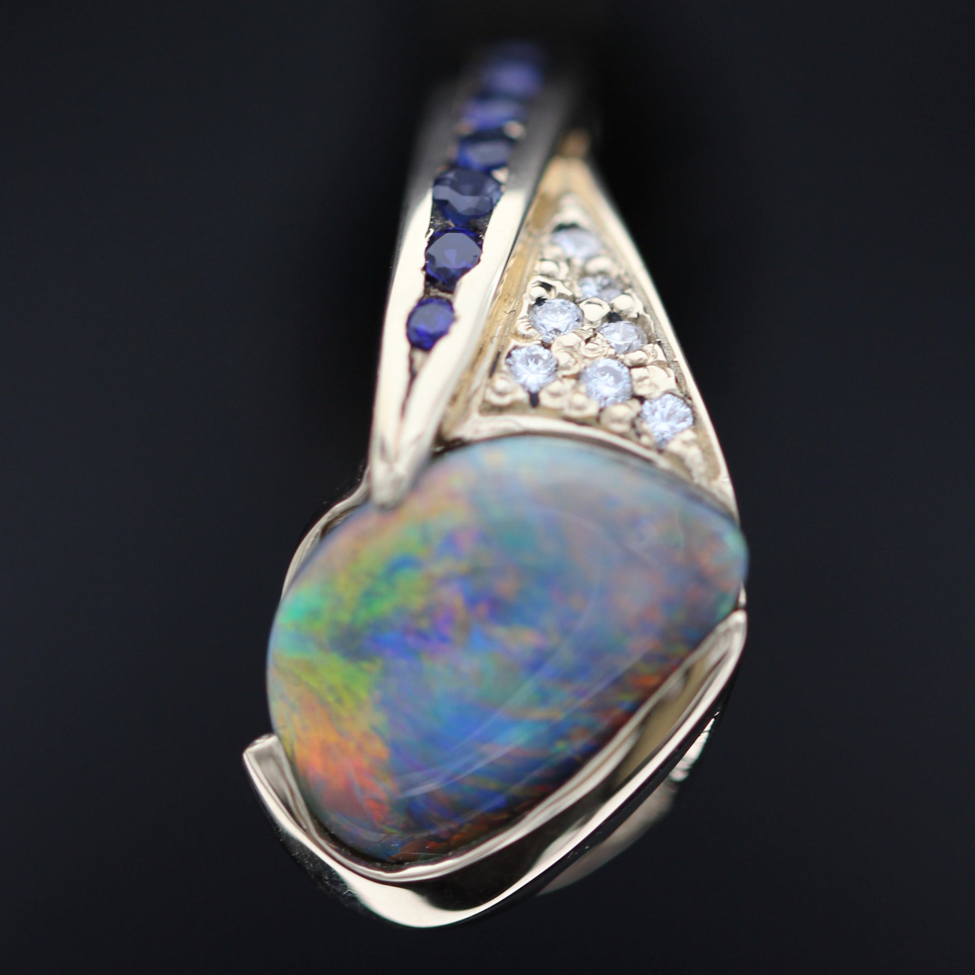 Side profile macro showing the sculpted gallery and bezel of a Lightning Ridge black opal statement ring in 18ct yellow gold.