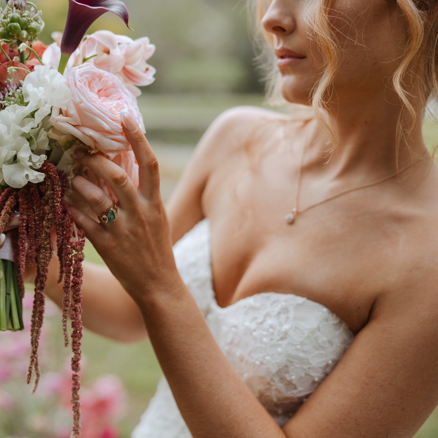 Bridal portrait showing 2.75ct black opal, diamond and ruby ring on hand.