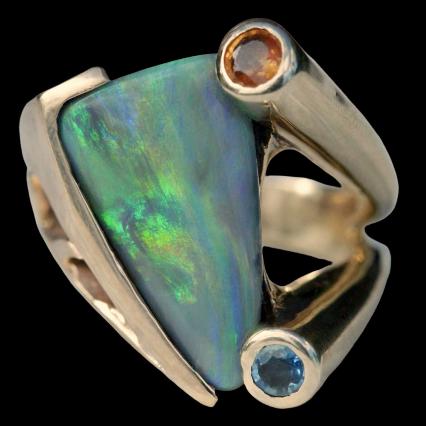 Close-up of 4.77ct green-blue Lightning Ridge opal with bezel blue and orange sapphires in 14ct yellow gold setting.