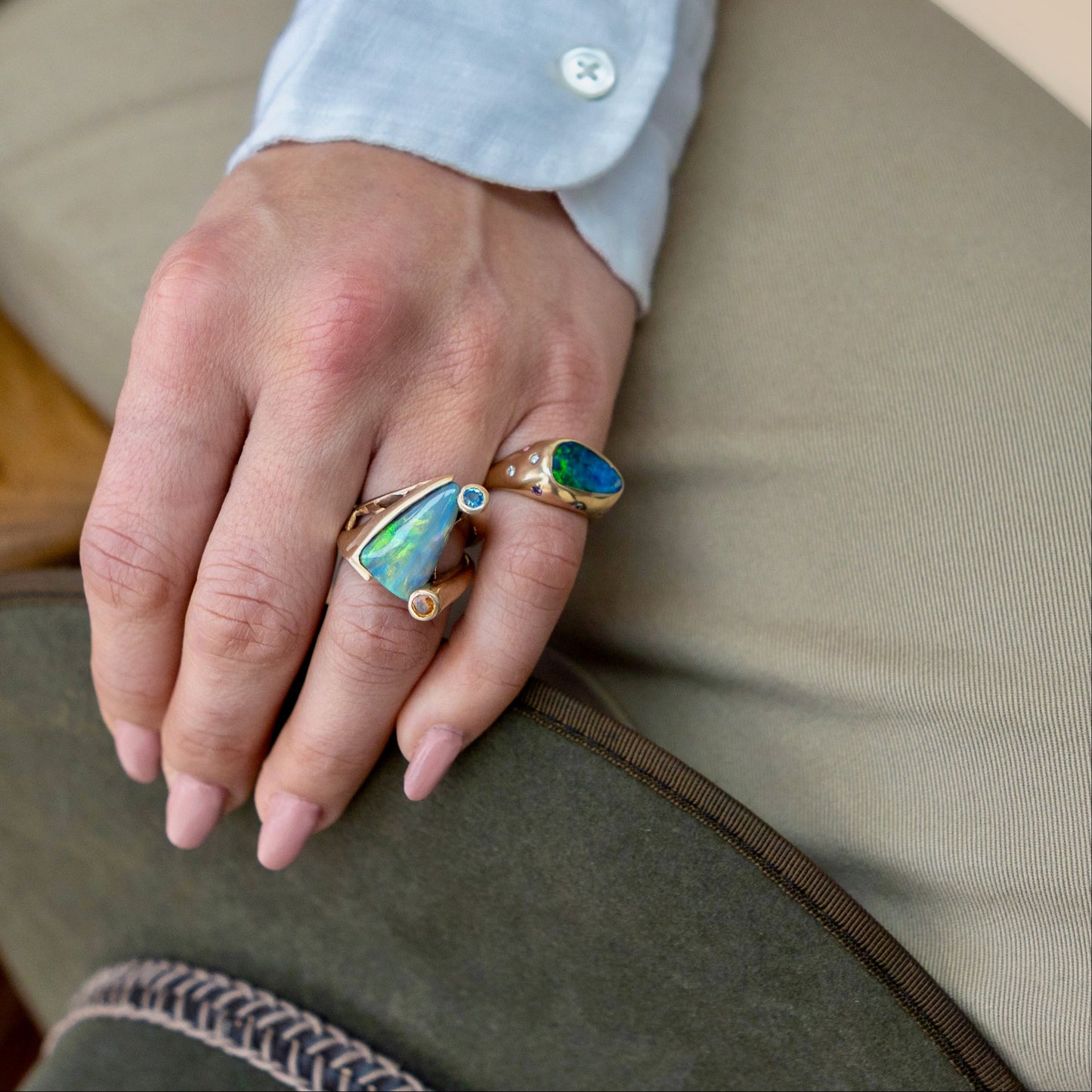 Styled hand stack showing unisex 4.77ct Lightning Ridge opal ring with blue and orange sapphires, 14ct yellow gold.