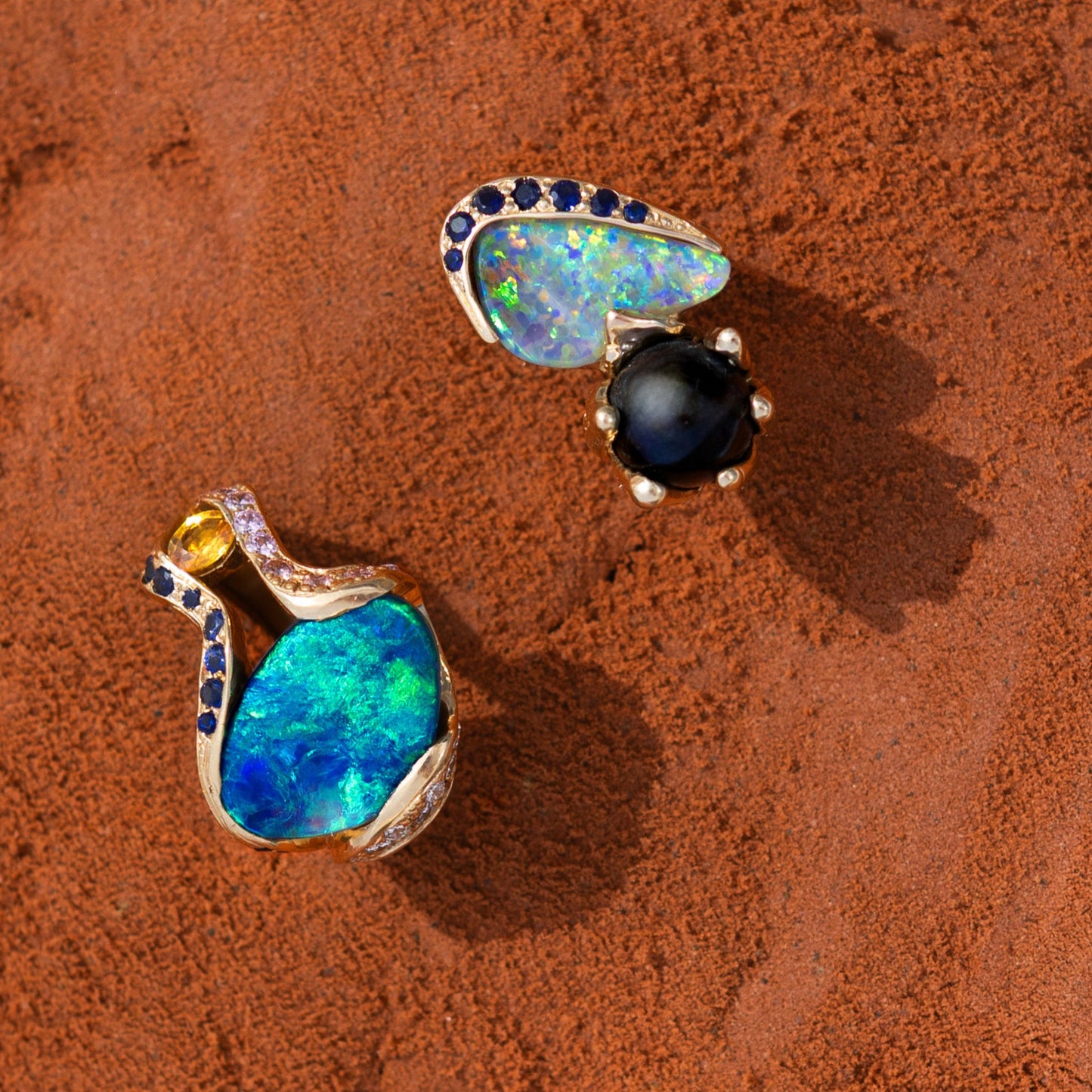 Flat-lay of two opal rings; featured 5.85ct Lightning Ridge opal cocktail ring with yellow sapphire and diamond accents in 18ct yellow gold.