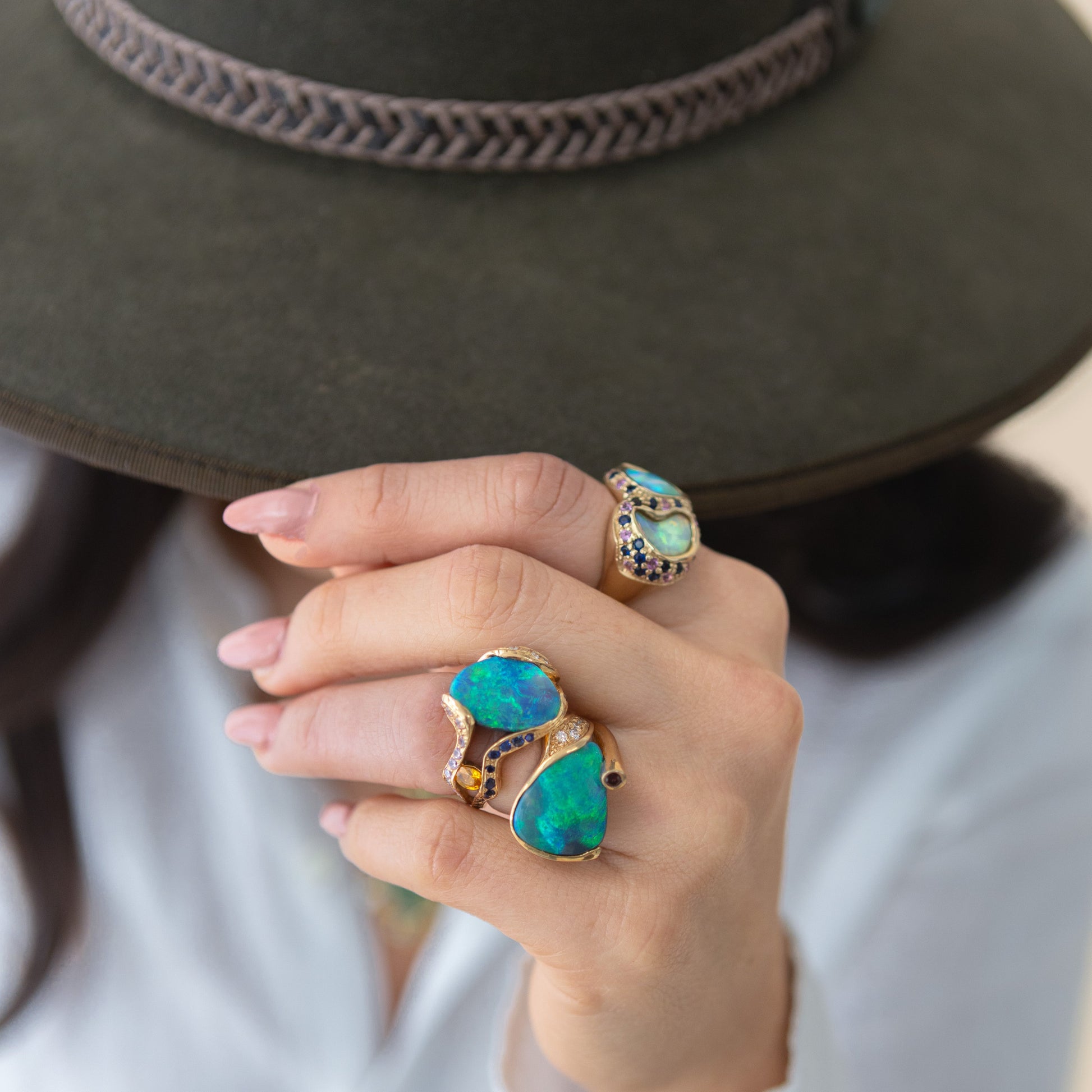 Model wearing 5.45ct Lightning Ridge opal, ruby and diamond cocktail ring in 18ct yellow gold on the hand.