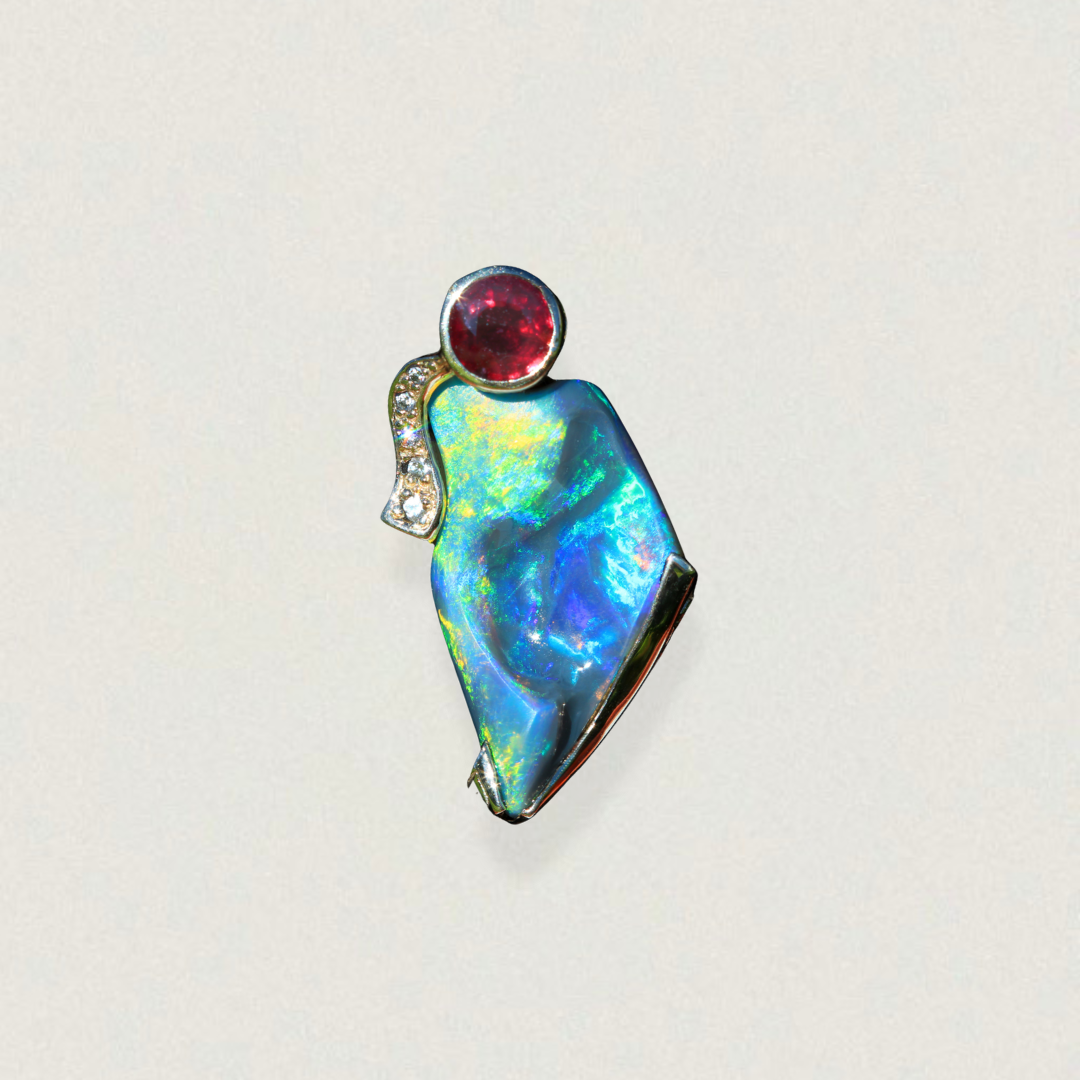 Freeform Lightning Ridge opal pendant with round ruby and diamond accent in 14ct yellow gold, studio shot on light background.