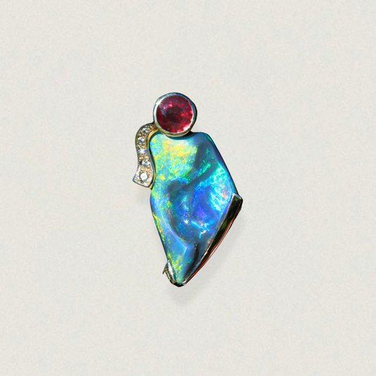 Freeform Lightning Ridge opal pendant with round ruby and diamond accent in 14ct yellow gold, studio shot on light background.