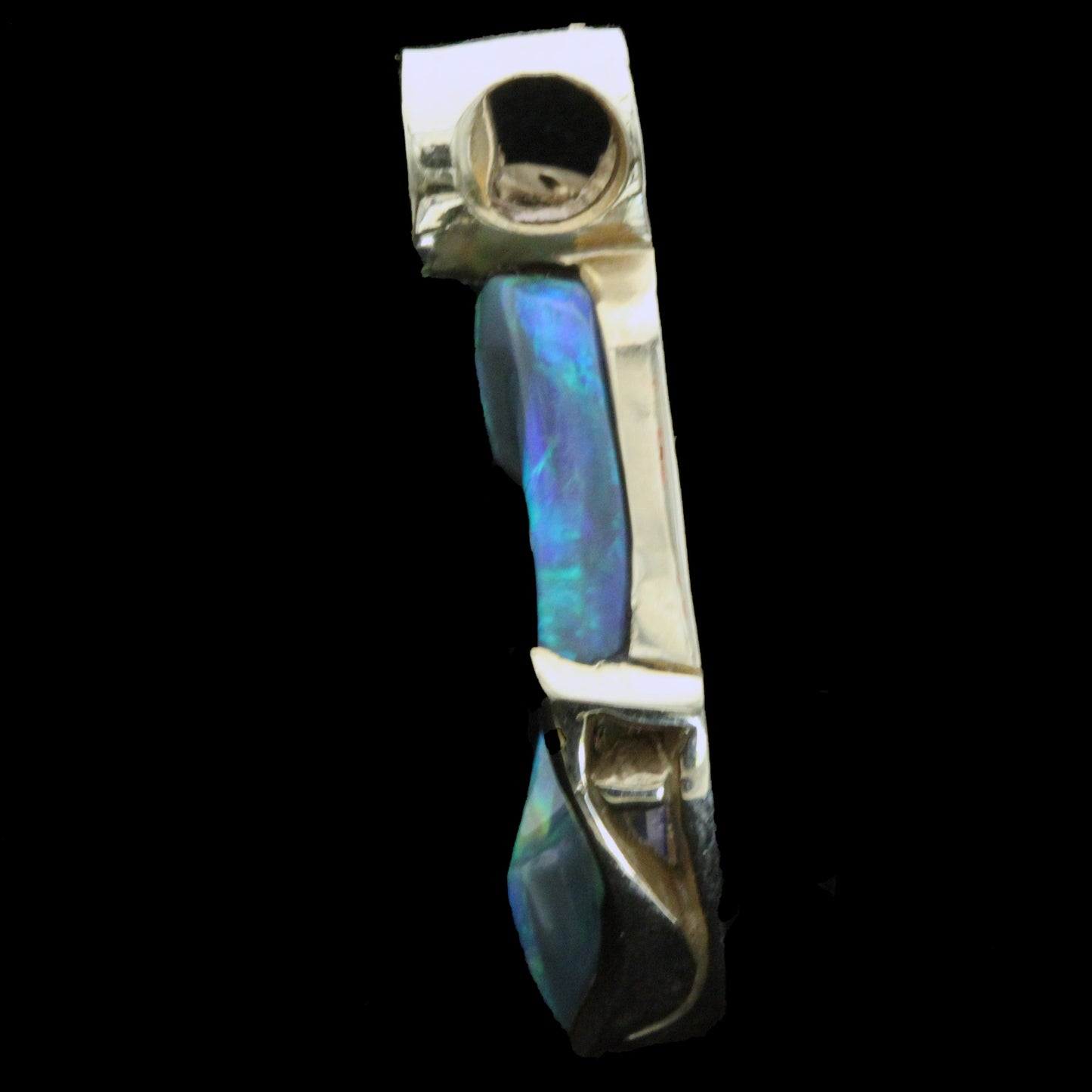 Left side profile of the opal, ruby and diamond pendant highlighting the gold gallery and depth of the stone.