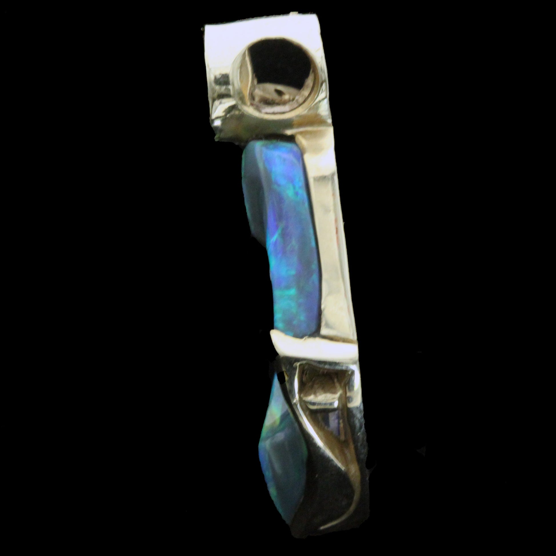 Left side profile of the opal, ruby and diamond pendant highlighting the gold gallery and depth of the stone.