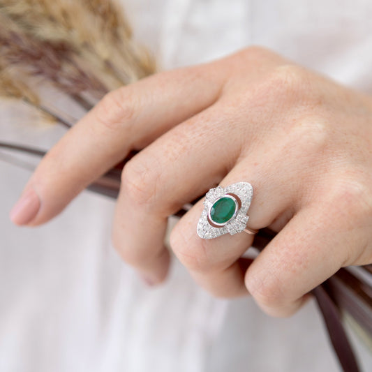 Art Deco emerald and diamond halo ring in 18ct white gold shown on hand for scale.