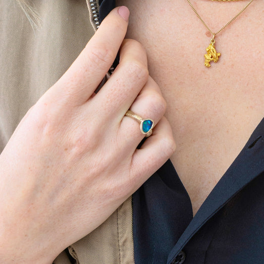Model wearing 0.70ct Lightning Ridge black opal ring in 14k yellow gold on right hand.