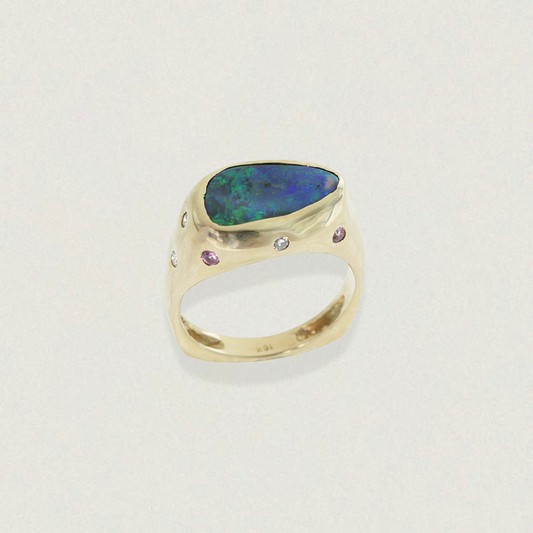 Lightning Ridge black opal ring in 18ct yellow gold with flush-set diamonds and pink sapphires, front three-quarter view.