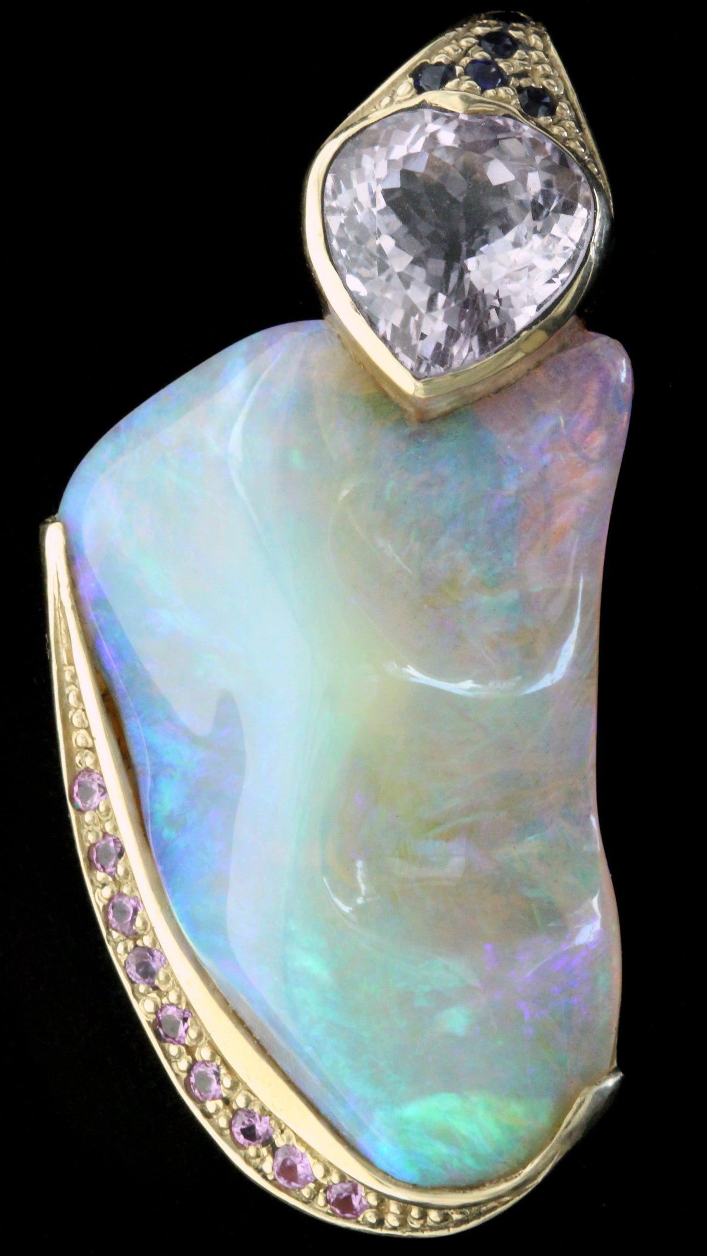 Close-up of 50ct Lightning Ridge crystal opal pendant, yellow-gold setting with pavé pink sapphires and a cushion amethyst.