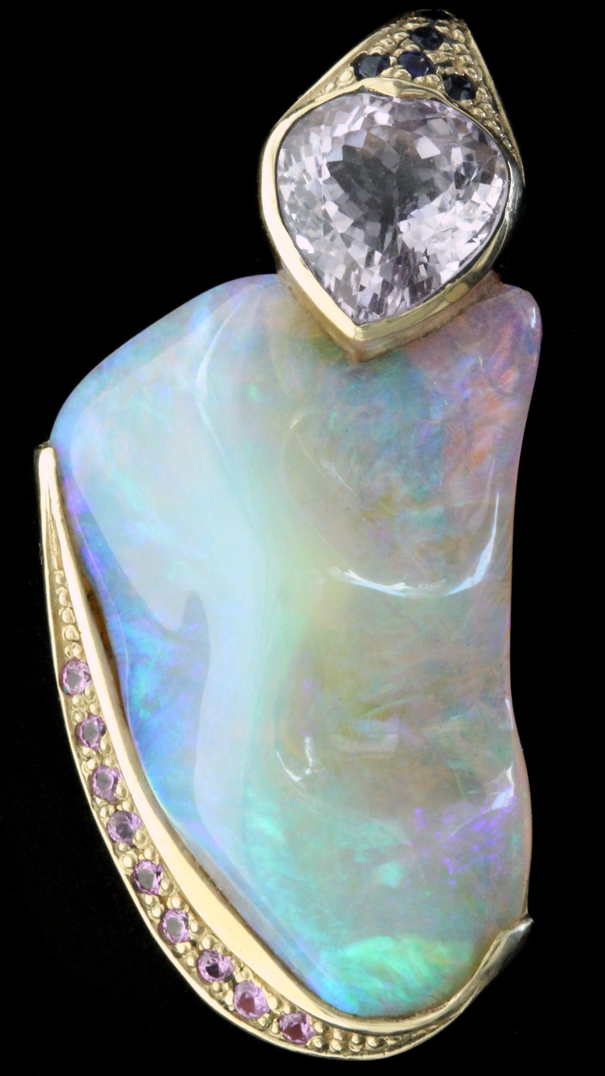 Close-up of 50ct Lightning Ridge crystal opal pendant, yellow-gold setting with pavé pink sapphires and a cushion amethyst.