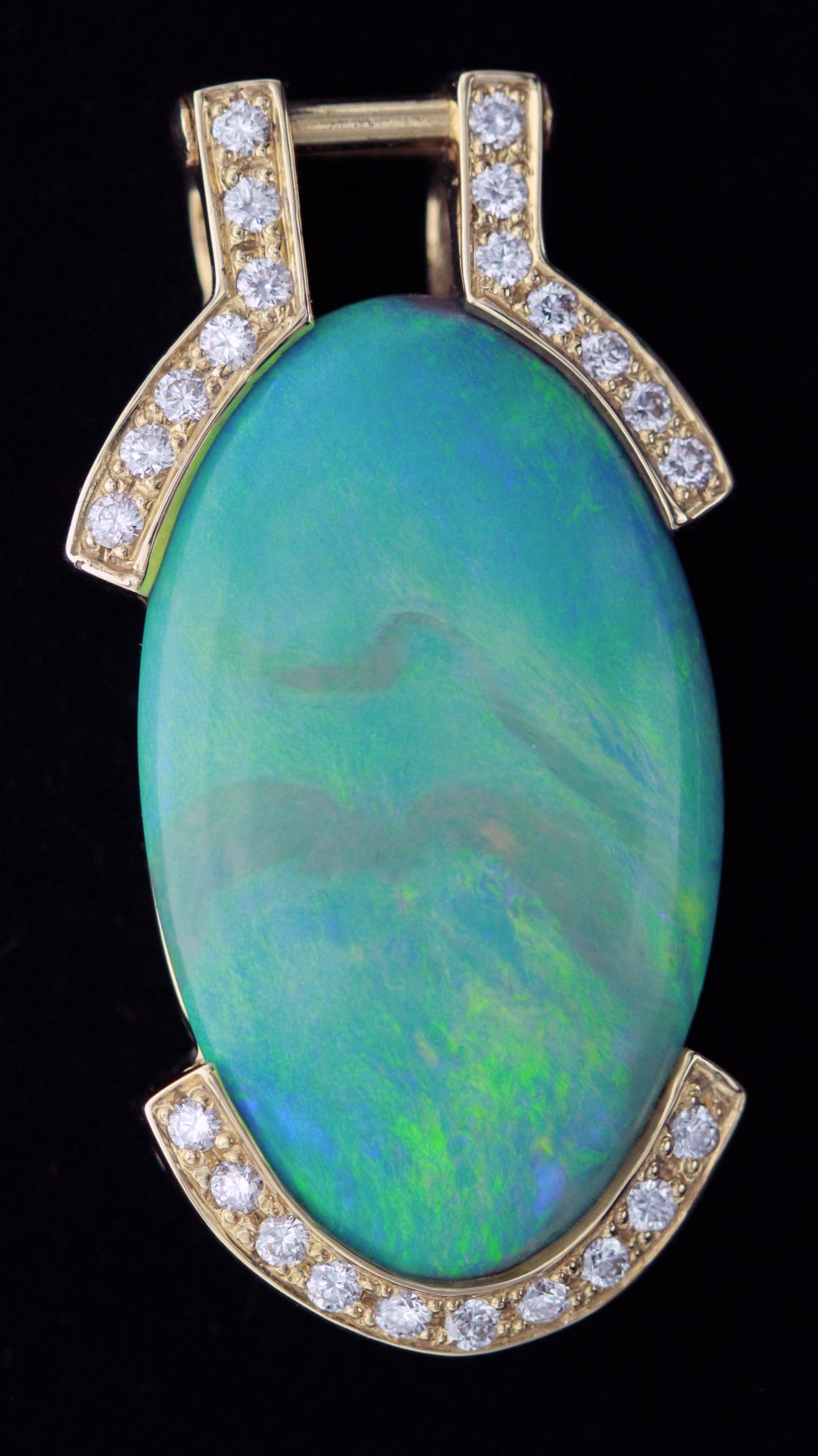 Close-up of oval Lightning Ridge opal pendant with diamond-set top and bottom in 18ct yellow gold — detailed front