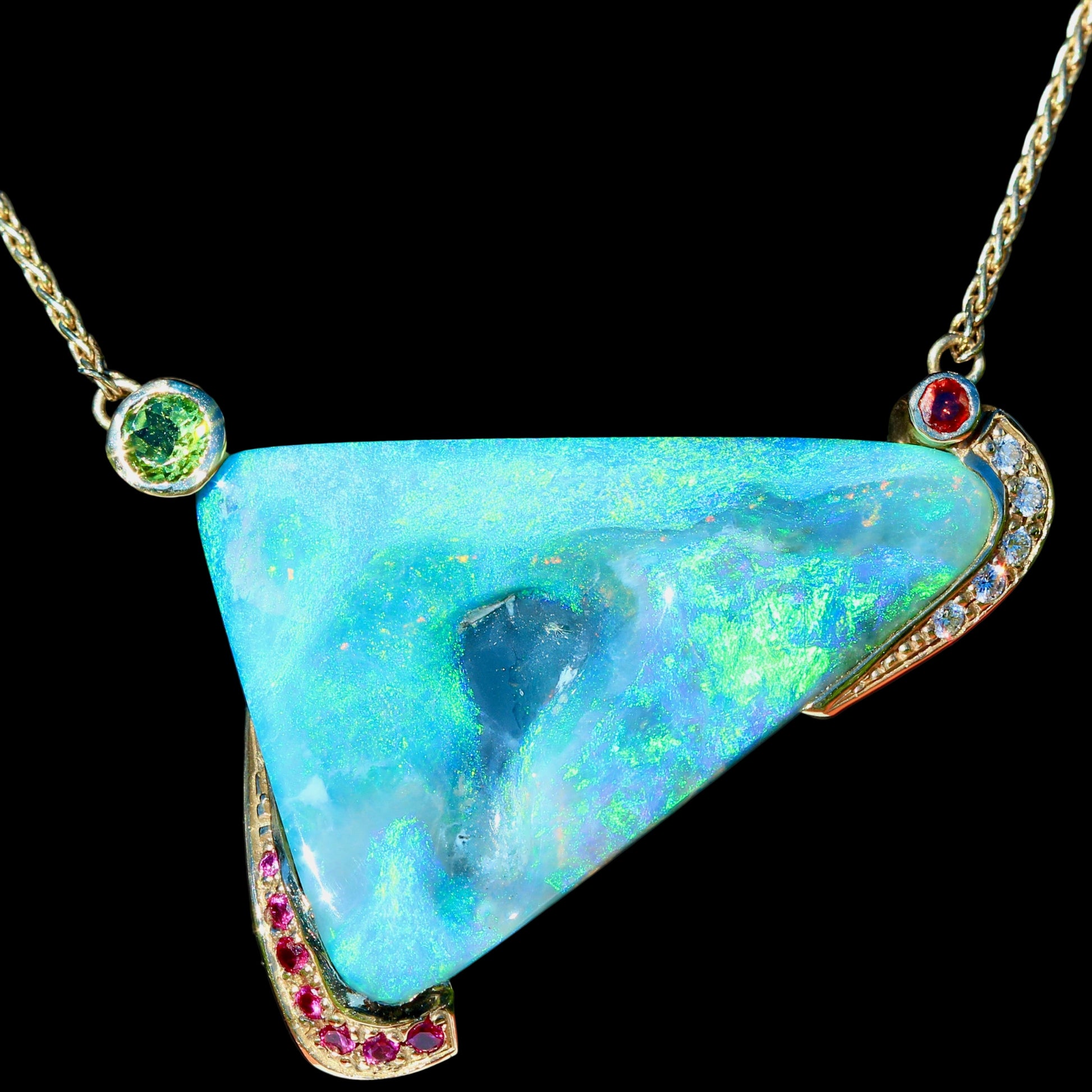 Close-up of 46.84ct Lightning Ridge opal triangle pendant with diamond, garnet, peridot and pink sapphire.