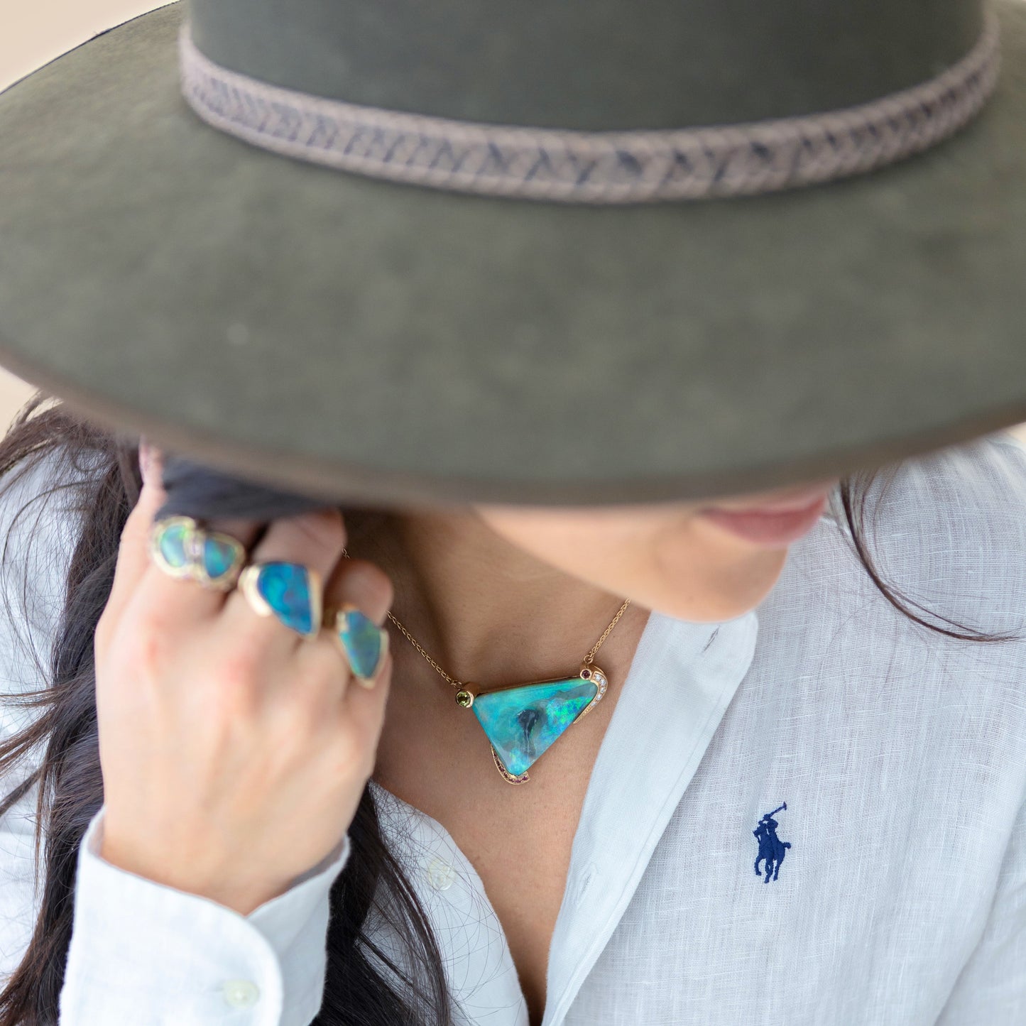 Model wearing Lightning Ridge opal triangle pendant in 14ct yellow gold with multicolour gemstone accents.