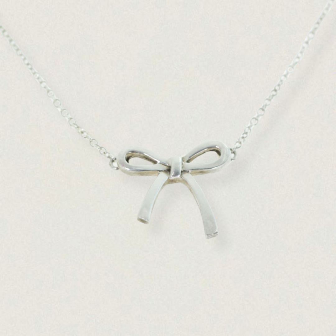 Vintage Tiffany & Co. Elsa Peretti Bow pendant necklace in sterling silver, late 1990s — product on light background