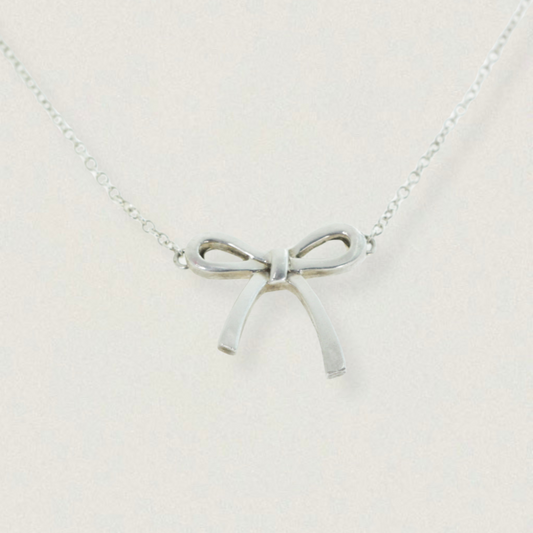 Vintage Tiffany & Co. Elsa Peretti Bow pendant necklace in sterling silver, late 1990s — product on light background