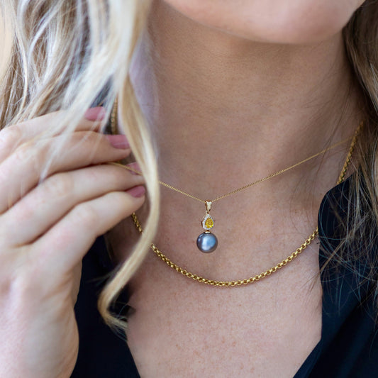 Yellow sapphire, diamond and Tahitian pearl pendant in 14ct yellow gold shown on neck for scale.