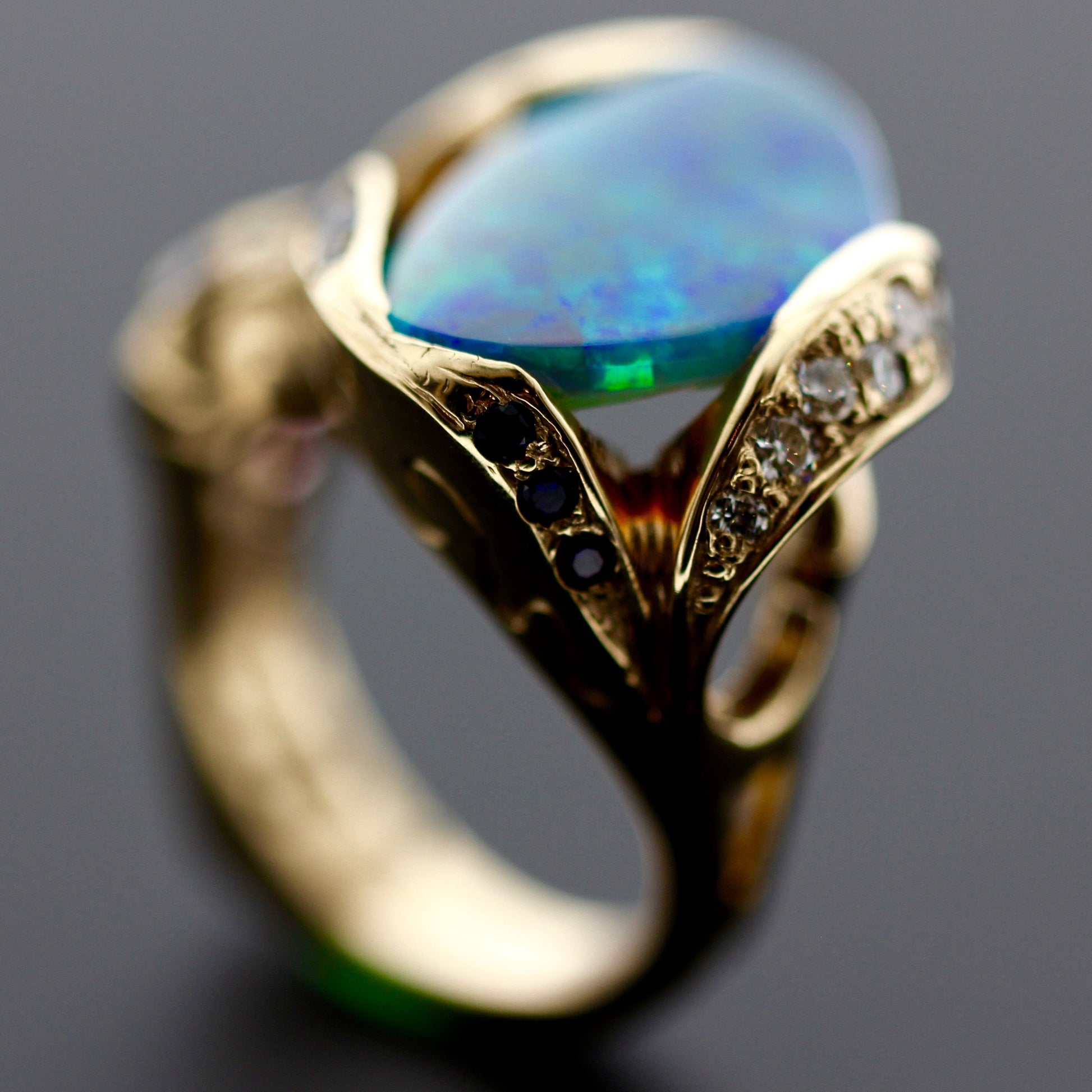 Profile close-up highlighting the wavy diamond shoulders and freeform opal on the 18ct yellow gold cocktail ring.